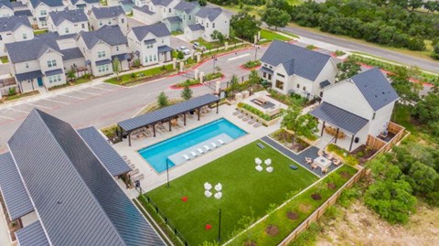 an aerial view of a pool and houses in a neighborhood