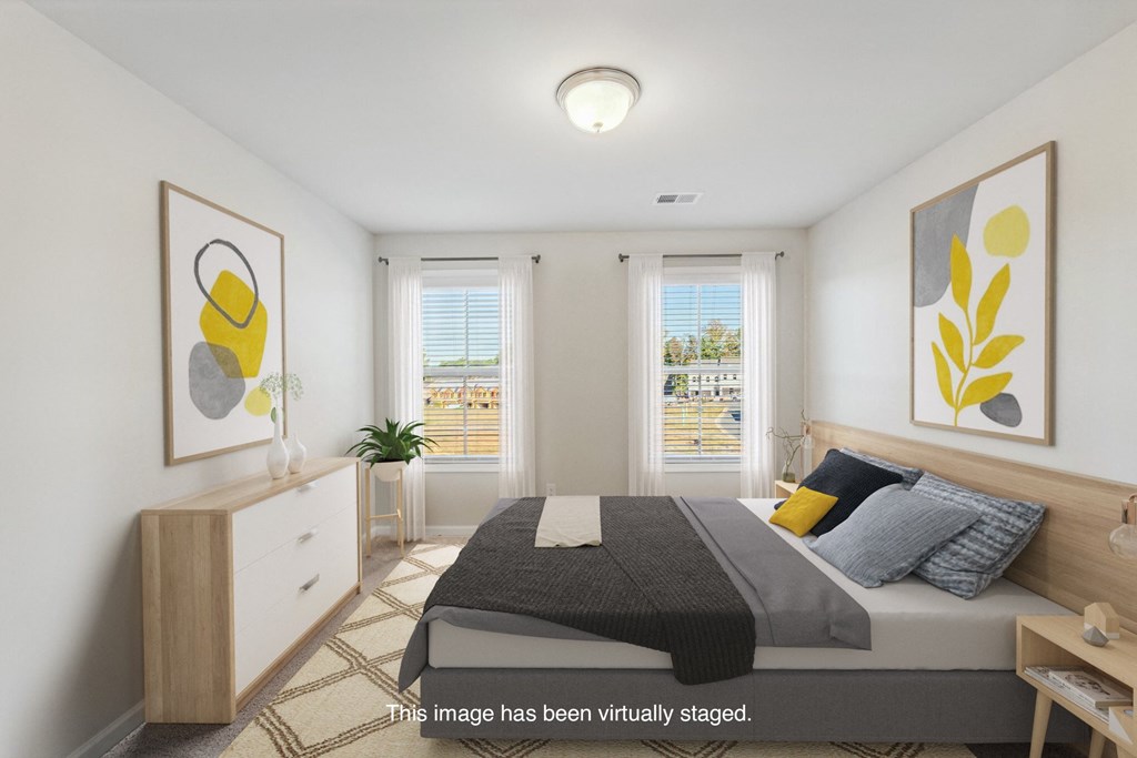 an image of a bedroom with a bed and two windows