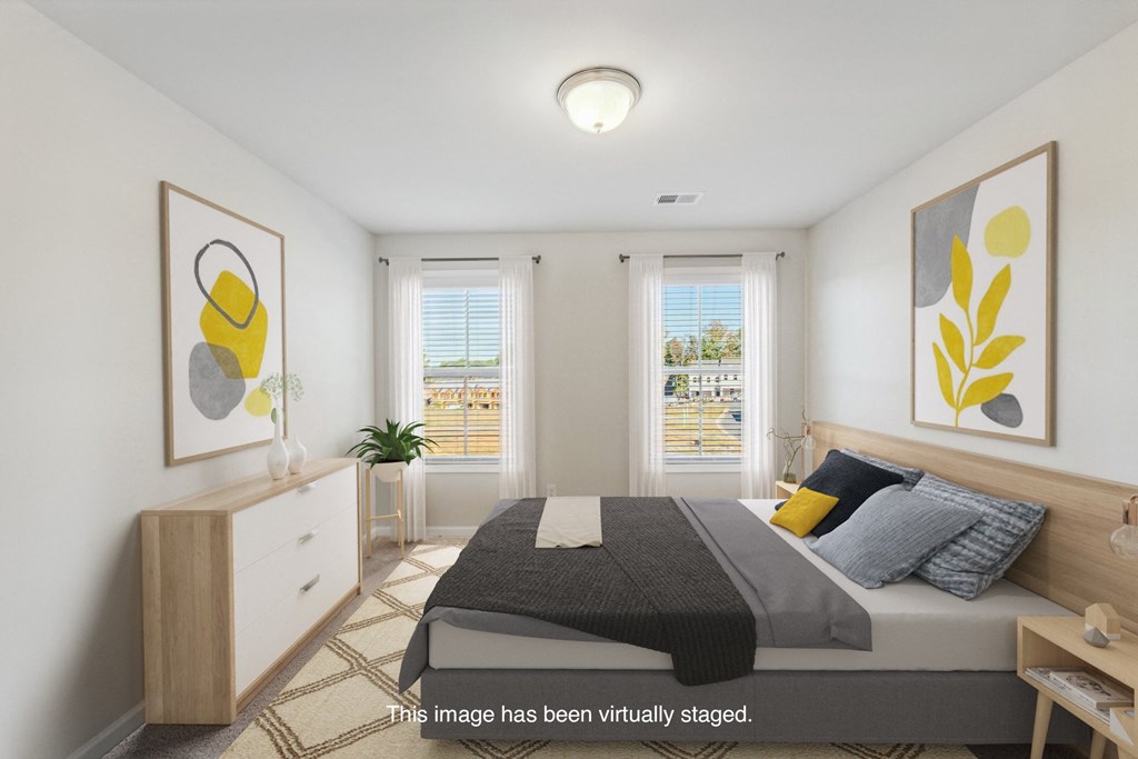 an image of a bedroom with a bed and two windows