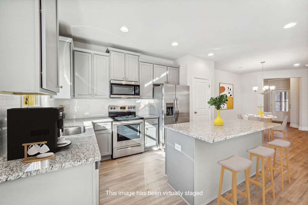 a kitchen with white cabinets and a marble counter top