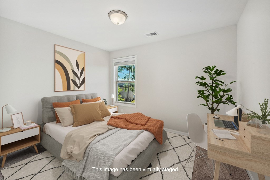 an image of a bedroom with a bed and a desk