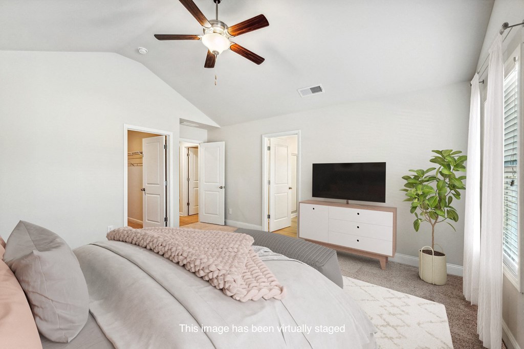 a bedroom with a large bed and a tv on the wall