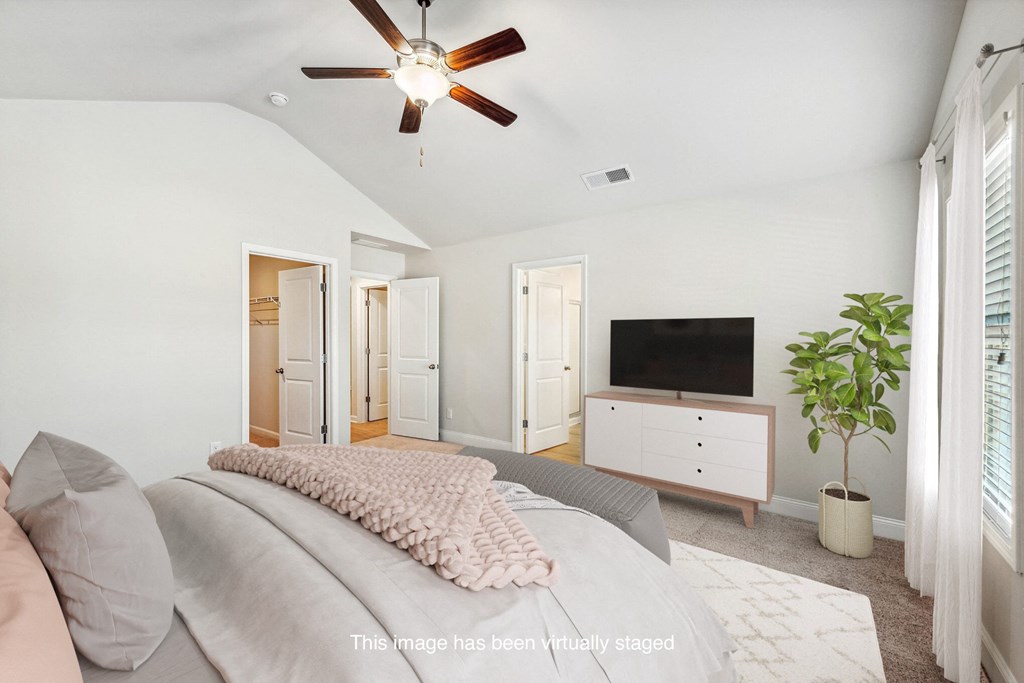 a bedroom with a large bed and a tv on the wall