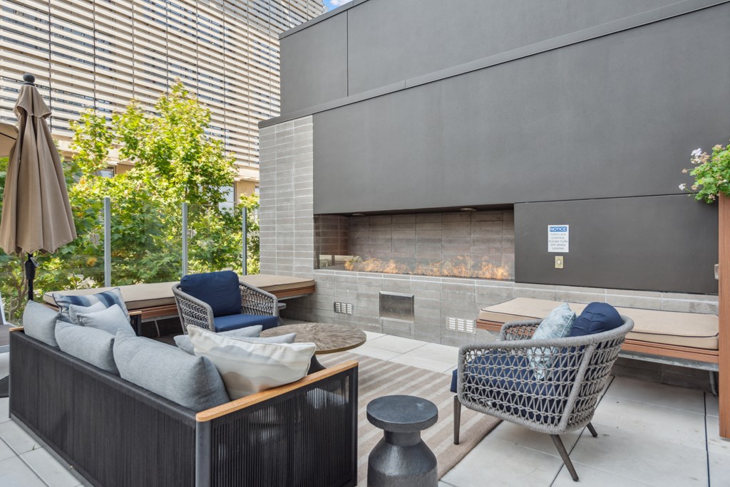 Living room with couches and chairs and a fireplace at K1 Apartments, California