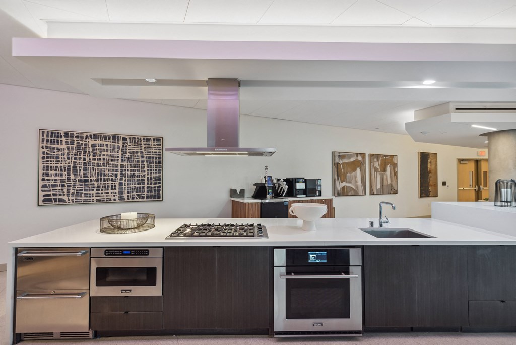 a kitchen with a white counter top and stainless steel appliances