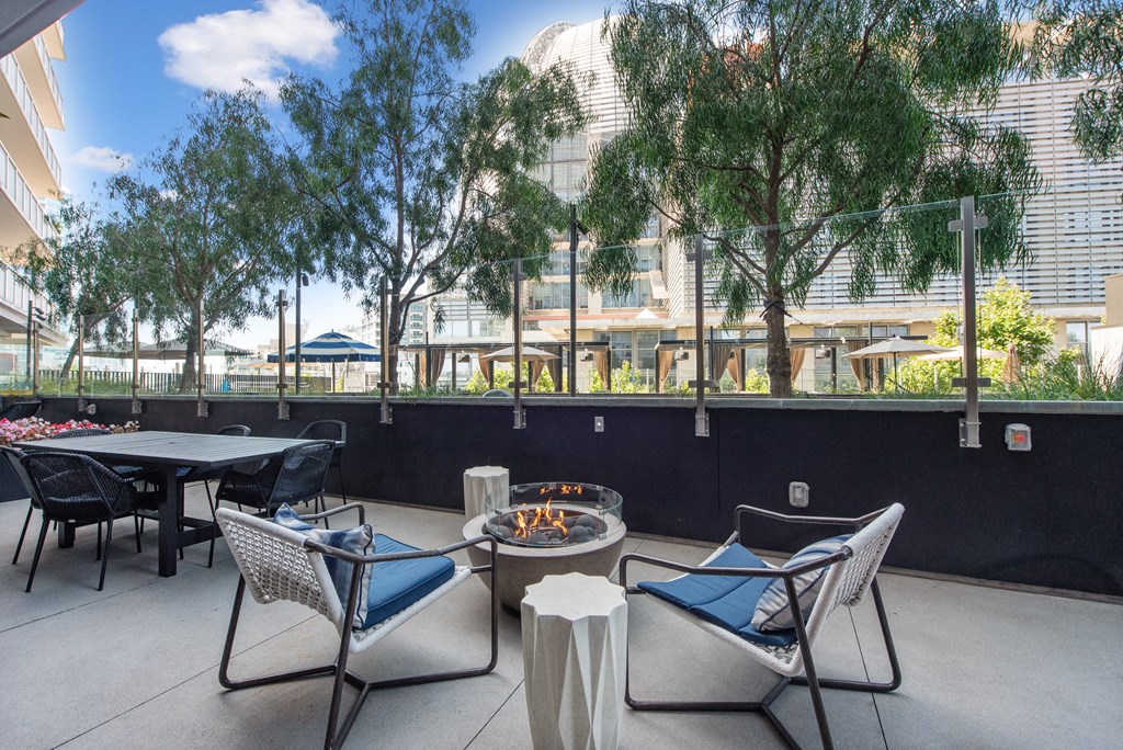 Outdoor patio with tables and chairs and a fire pit at K1 Apartments, San Diego