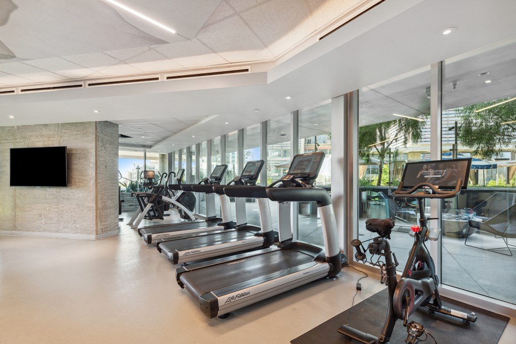 Gym with cardio machines and a television at K1 Apartments, San Diego, 92101