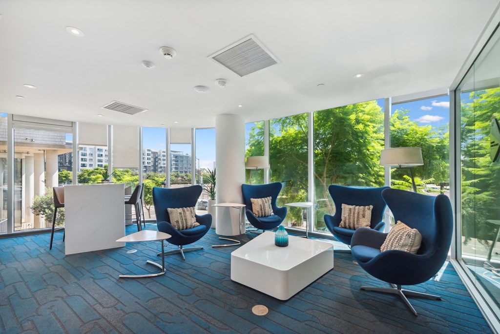 Living room filled with blue chairs at K1 Apartments, San Diego, California