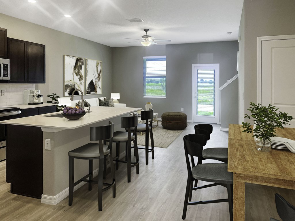 an open kitchen and living room with a bar and stools