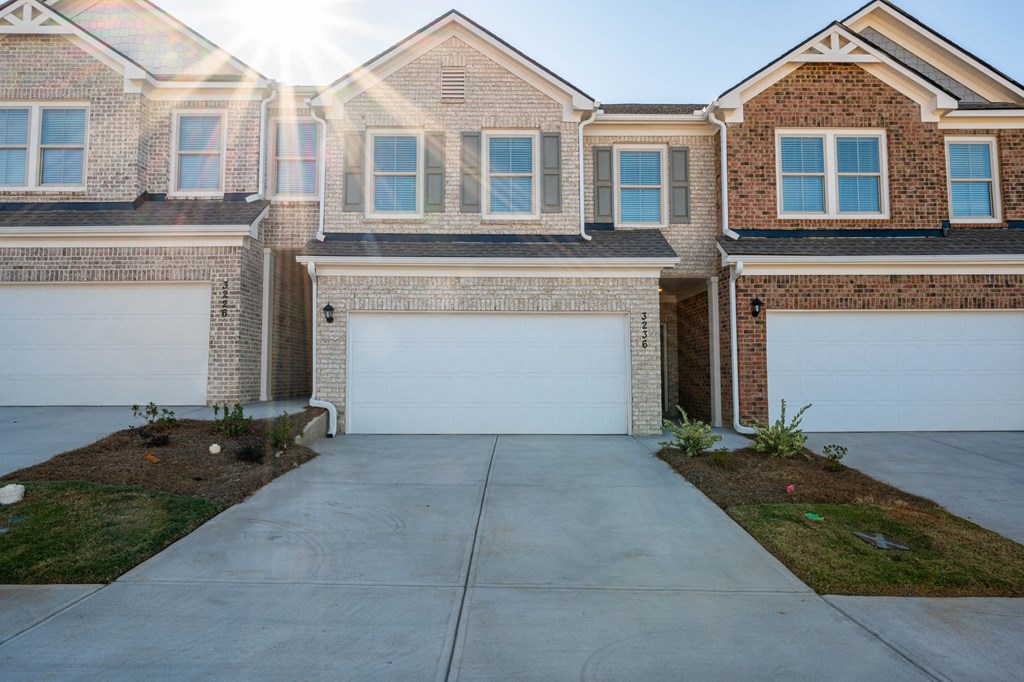a white garage door in front of a brick house