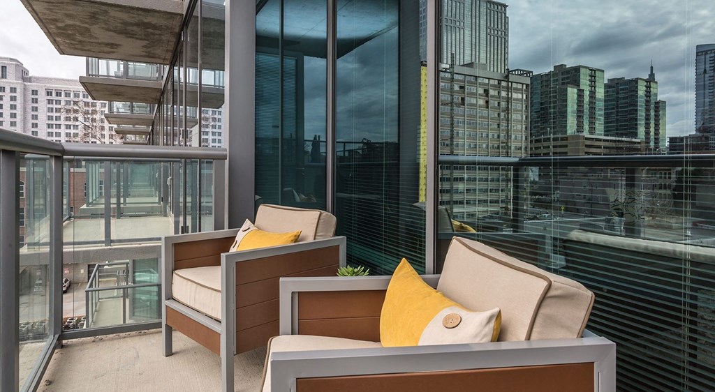 a balcony with chairs and a view of the city