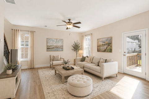 A living room with a white couch, a coffee table, and a ceiling fan.