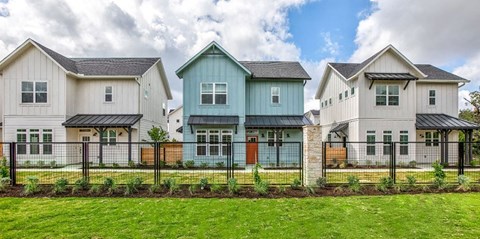a group of houses in front of a fence