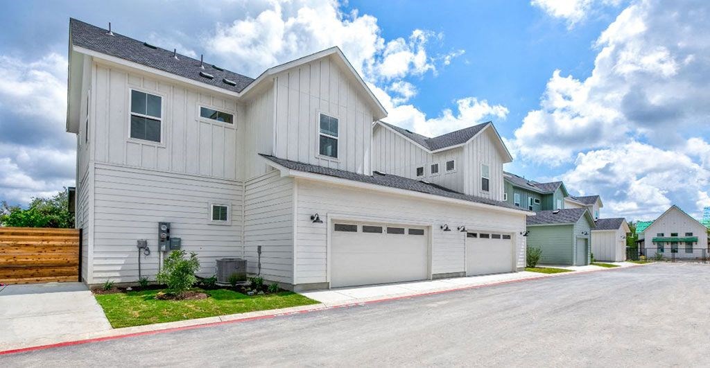 a white house with two garages and a driveway