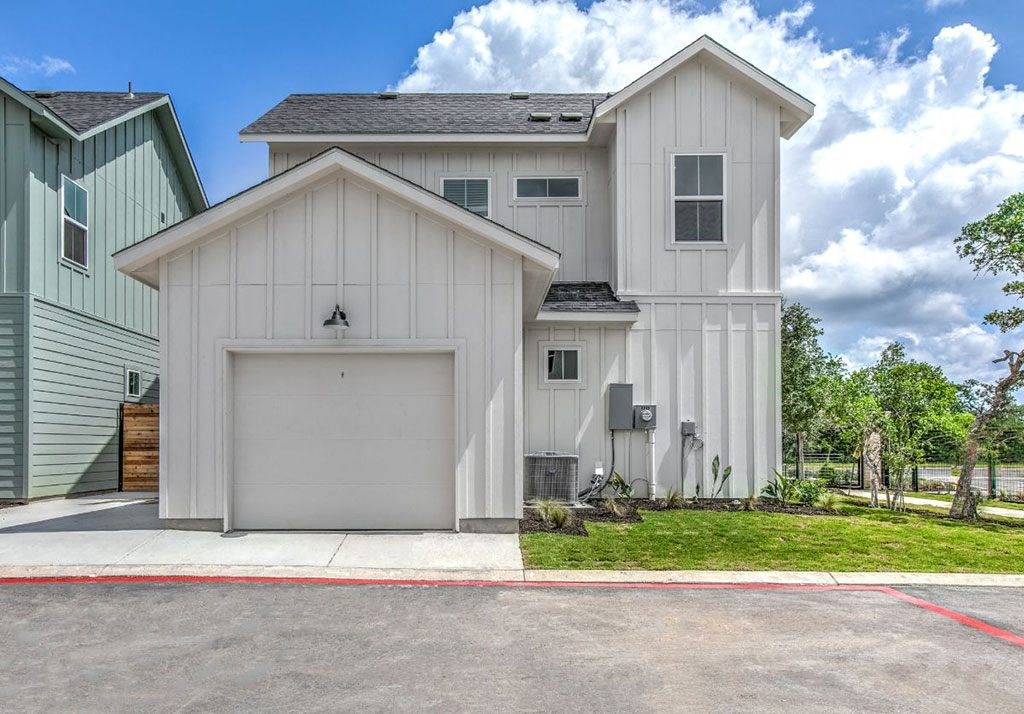 a white house with a garage and a lawn