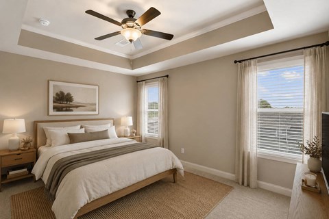A bedroom with a large bed and a ceiling fan.