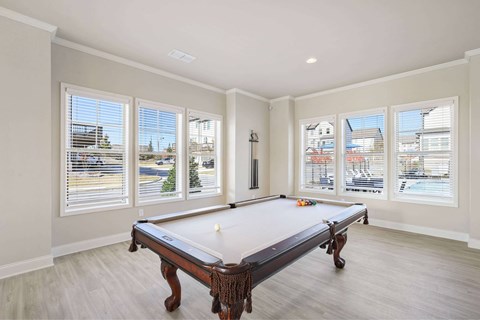 A pool table in a room with a view of the city.