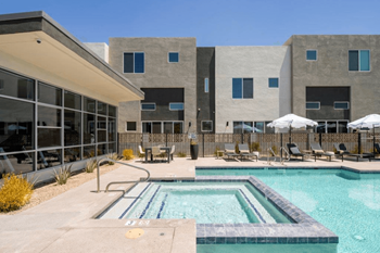 a swimming pool with chairs and a building in the background at Novella Biltmore, Arizona