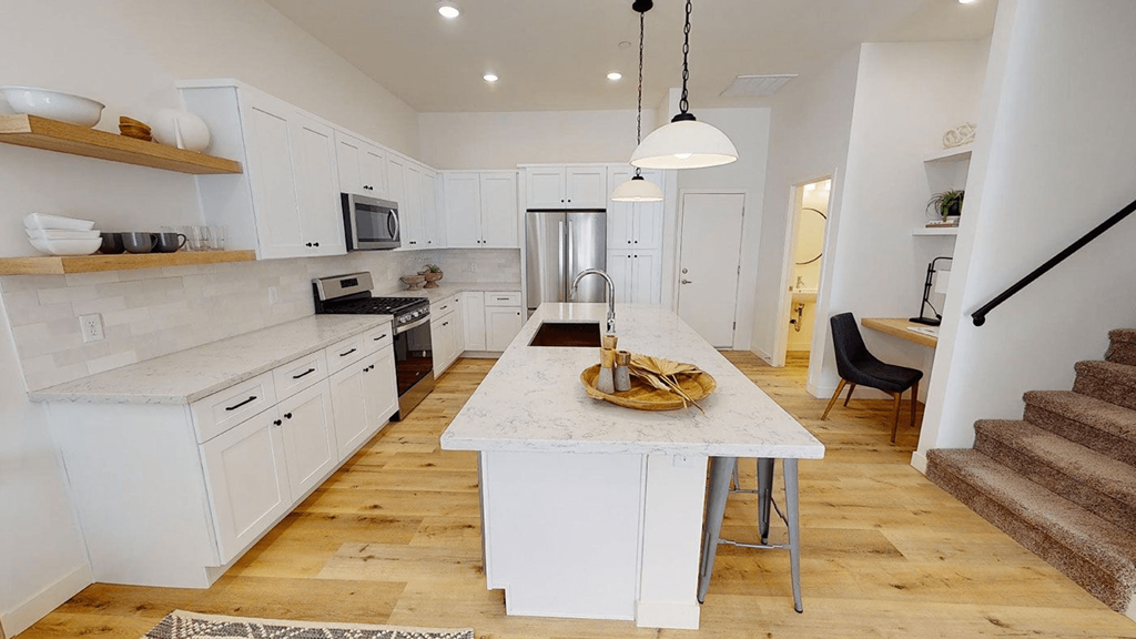 a large white kitchen with a marble counter top a large white kitchen with a marble counter top at Novella Biltmore, Phoenix, AZ