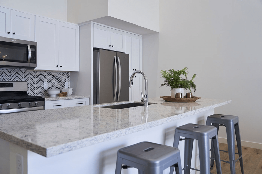 a kitchen with bar stools and a granite counter top at Novella Biltmore, Phoenix, AZ