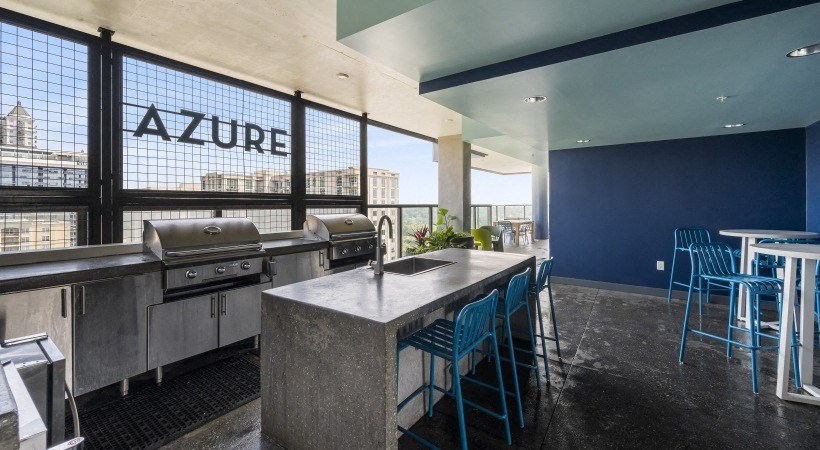 a kitchen with stainless steel appliances and a table with blue chairs