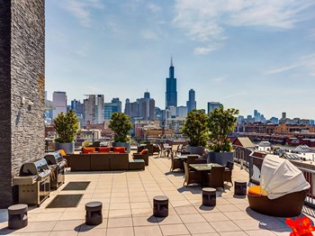 Community Beautiful Downtown Views at The Madison at Racine Rooftop outdoor grilling stations with a lounge area and skyline views at The Madison at Racine, Illinois, 60607 - Photo Gallery 4