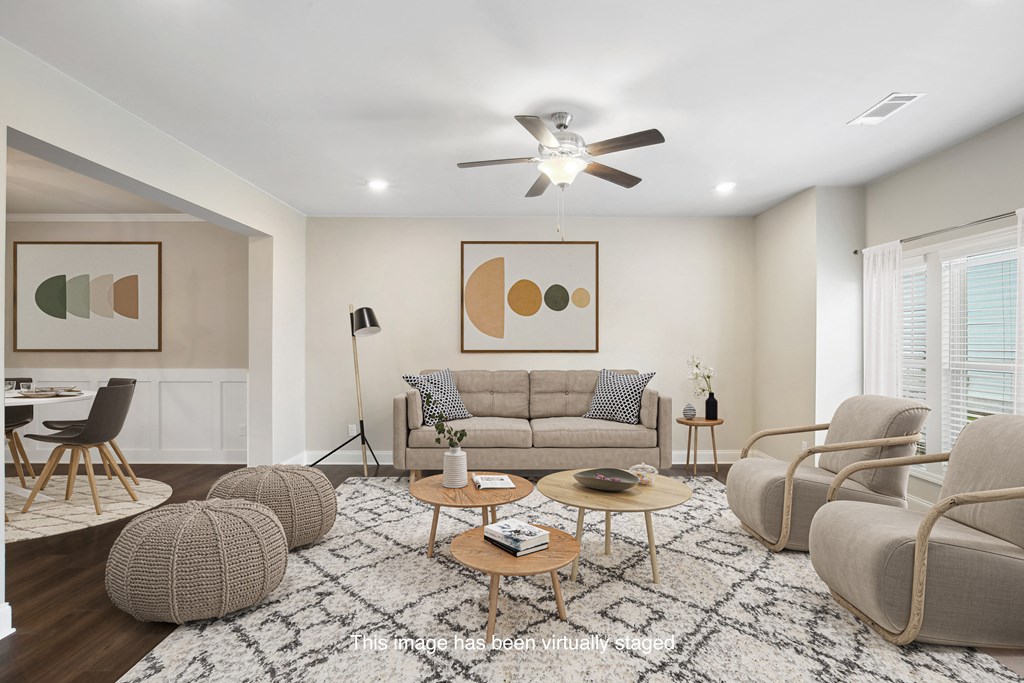 a living room with couches and chairs and a ceiling fan