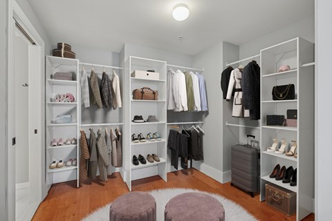 A spacious walk-in closet with organized shelves and clothes.