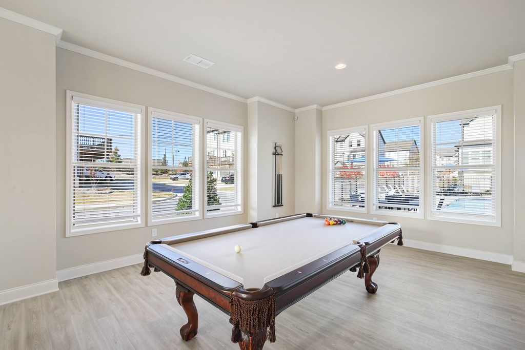 a game room with a pool table and windows
