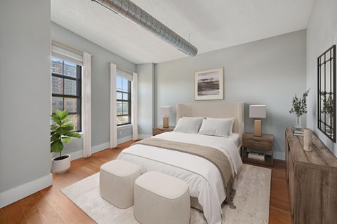 A bedroom with a large bed and a plant in a pot.
