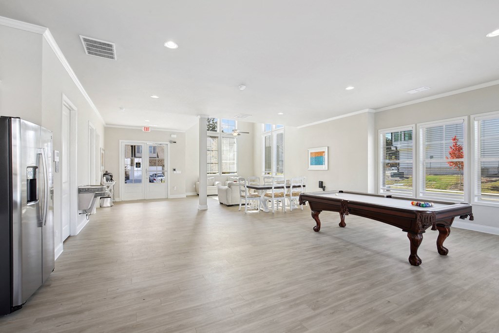 a game room with a pool table and a refrigerator