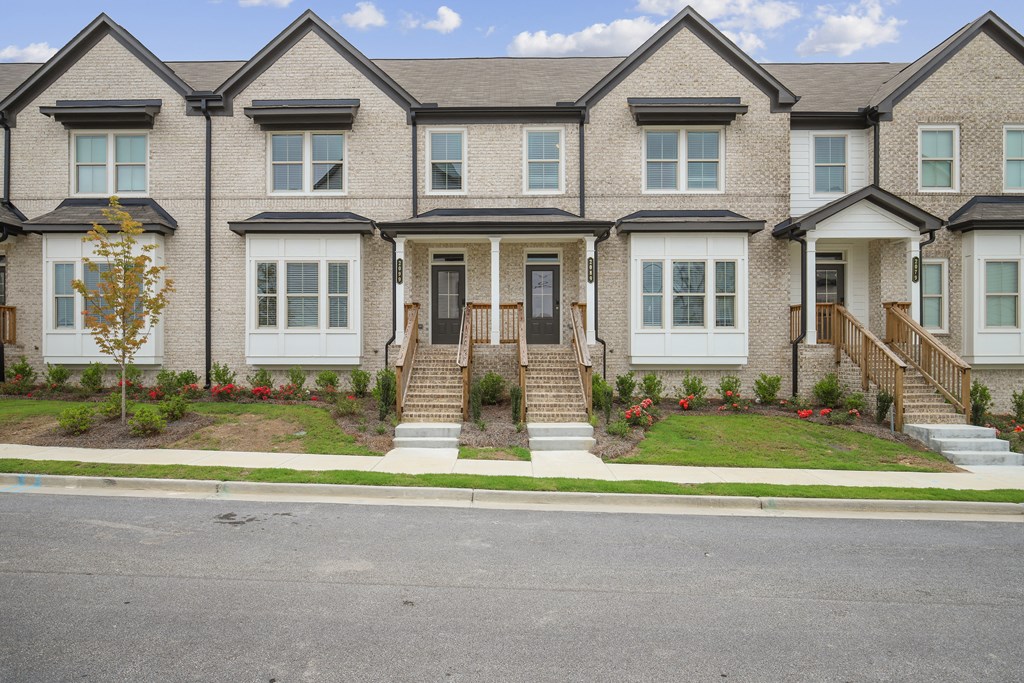 a row of townhomes on a street with a blue sky in the background