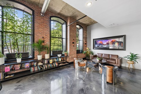 A living room with a brick wall and a large window.