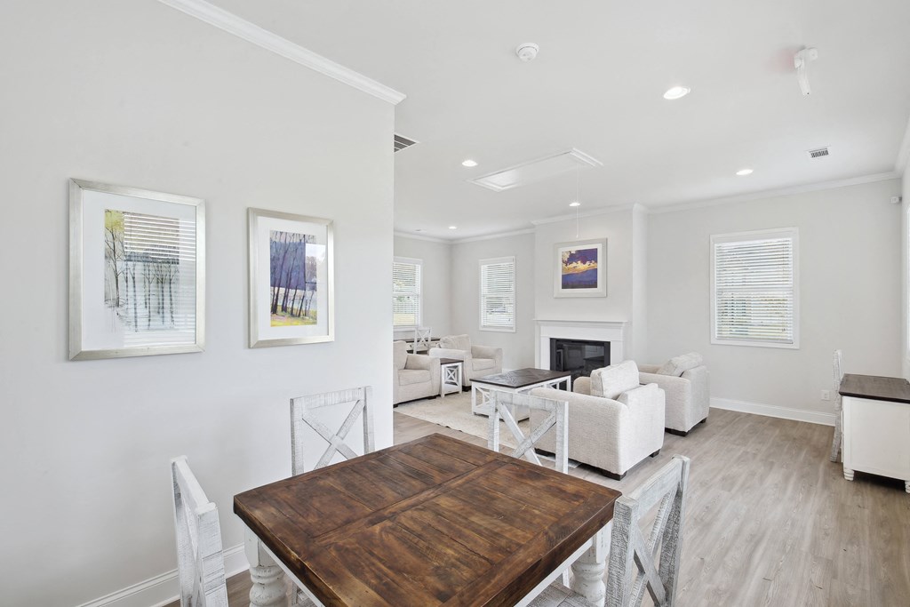 a living room with a wooden table and white furniture