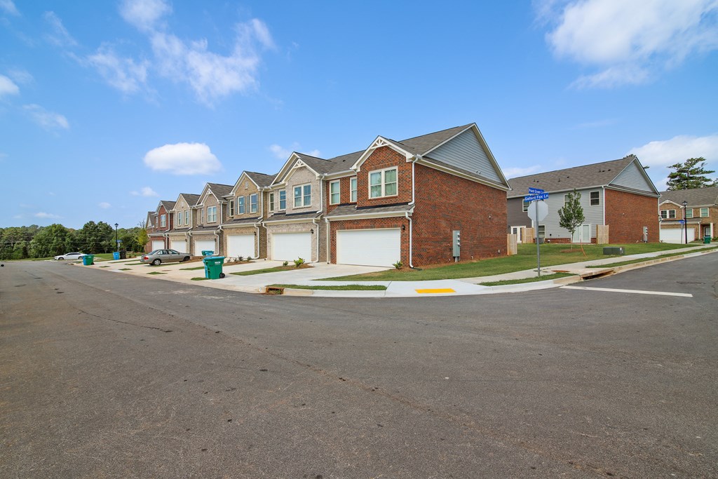 a row of houses on a street with a blue sky in the background