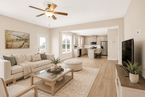 A living room with a couch, coffee table, and a ceiling fan.