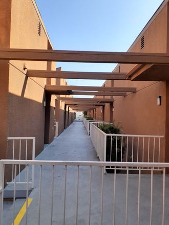 a covered walkway between two buildings with a gate