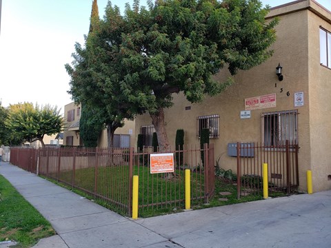 A brown building with a tree in front of it.