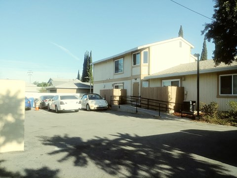 A white car is parked in front of a house.
