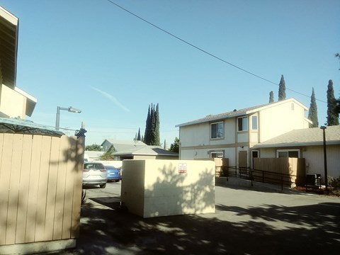 A sunny day in a residential area with houses and cars.