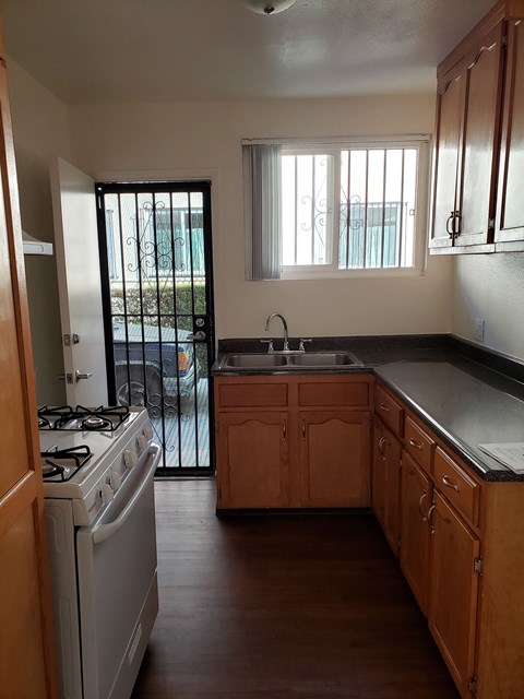 A kitchen with wooden cabinets and a white stove top oven.