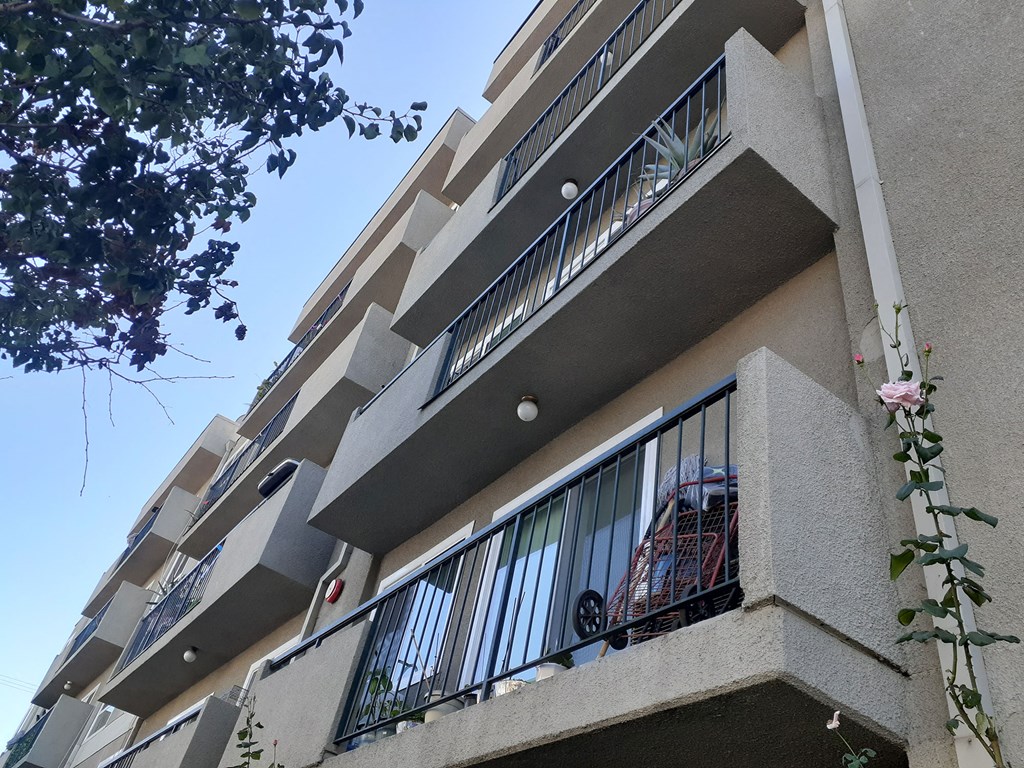 an apartment building with a balcony and a blue sky