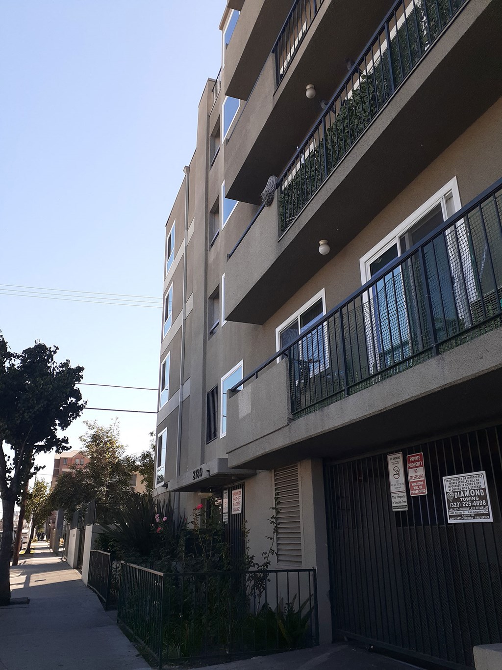 an apartment building with balconies and a sidewalk