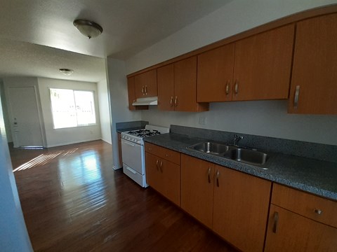 A kitchen with wooden cabinets and a white oven.