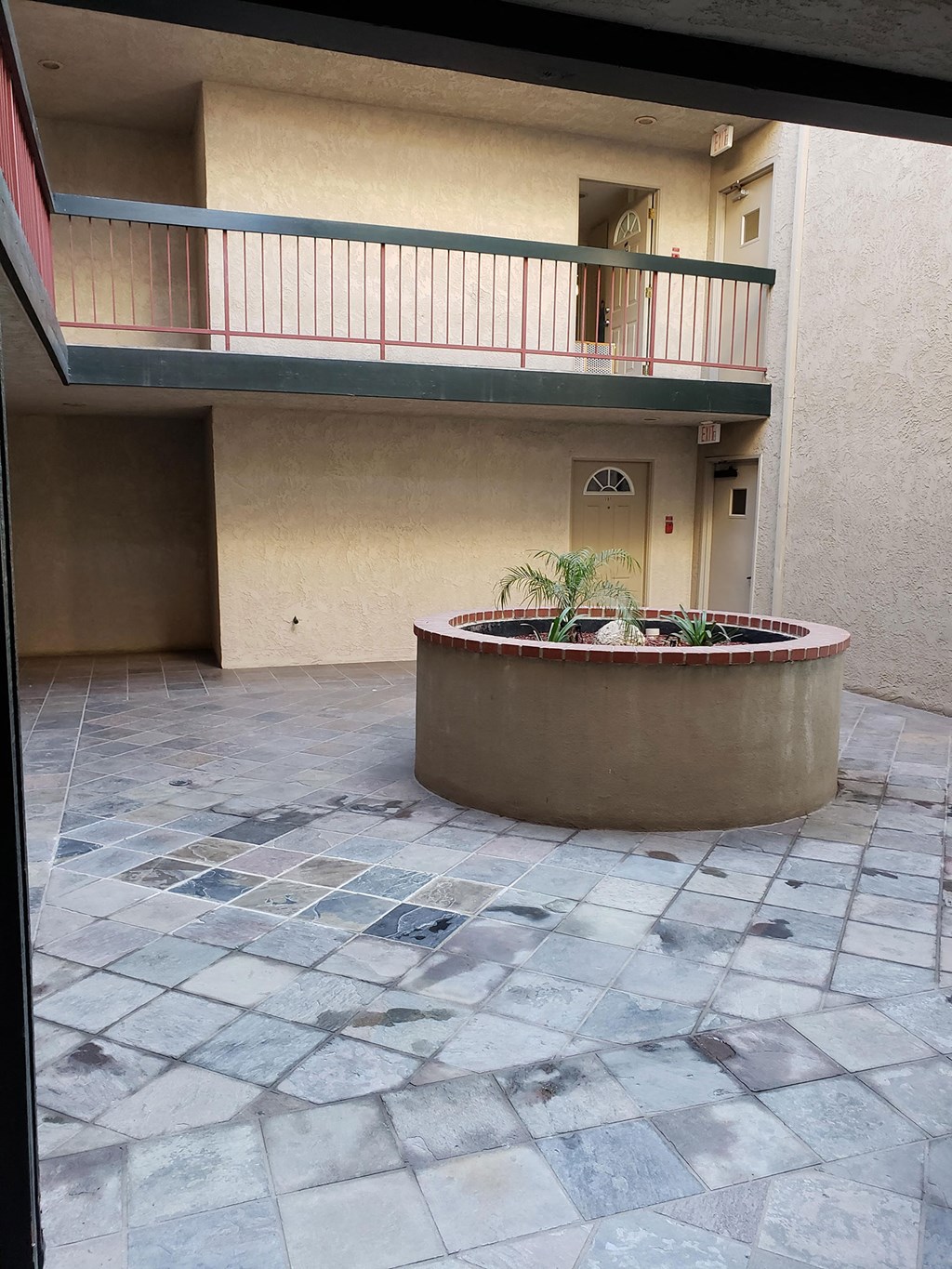 an empty courtyard with a fountain in front of a building