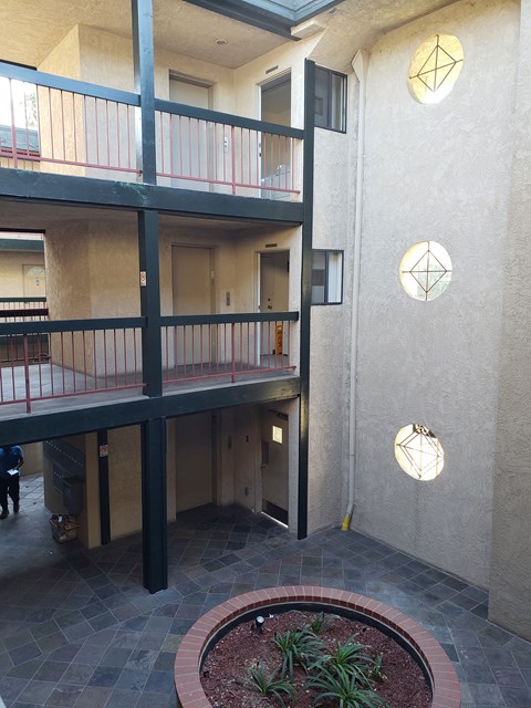 a view of the entrance of an apartment building with a courtyard