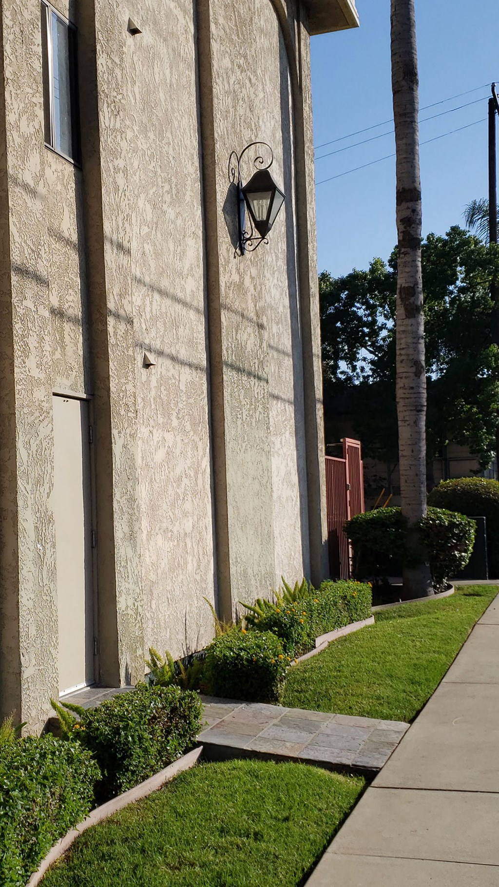 a sidewalk in front of a building with a lamp