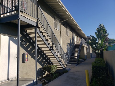 A staircase with a metal railing and a yellow pole on the side.