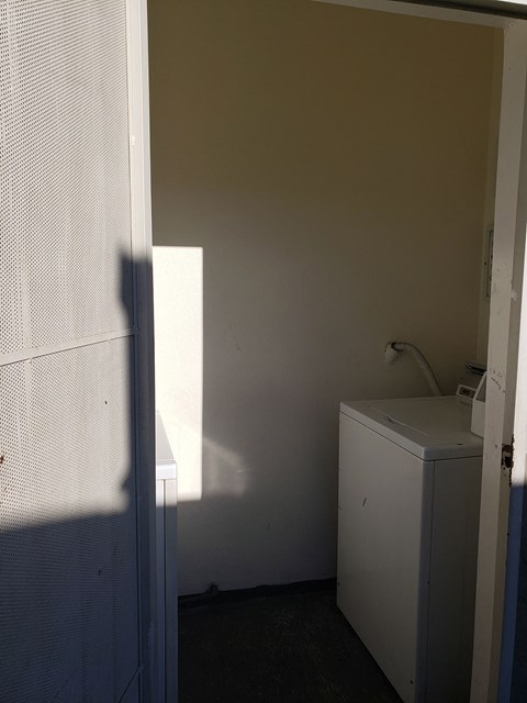 A white washing machine sits in a small room.