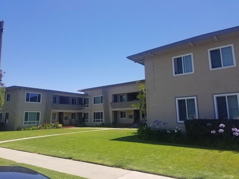 A building with a green lawn in front.